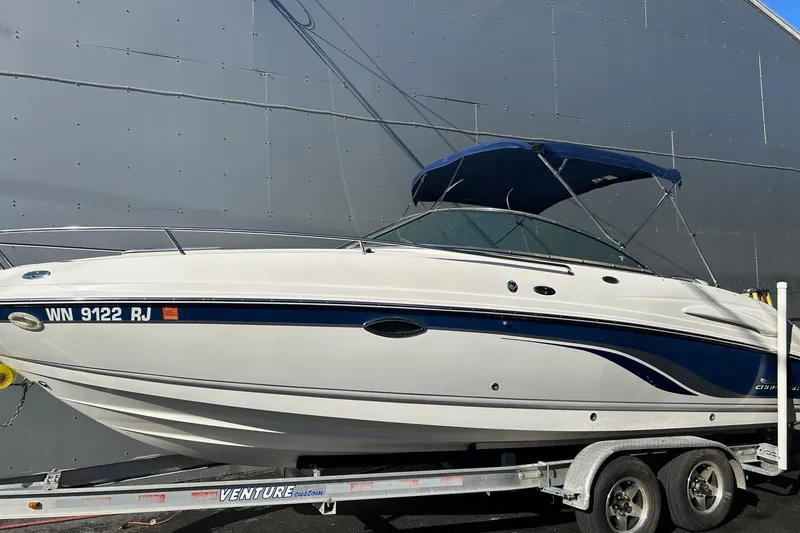 The Image of 2001 Chaparral 235 SSi boat on trailer with blue canopy and sleek design. - 0