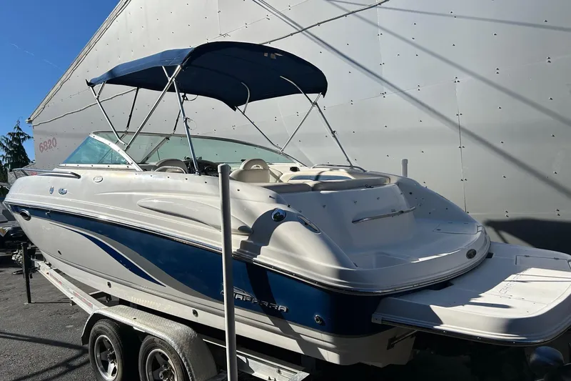 Slide: The Image of 2001 Chaparral 235 SSi boat with blue and white exterior, parked on a trailer. - 2