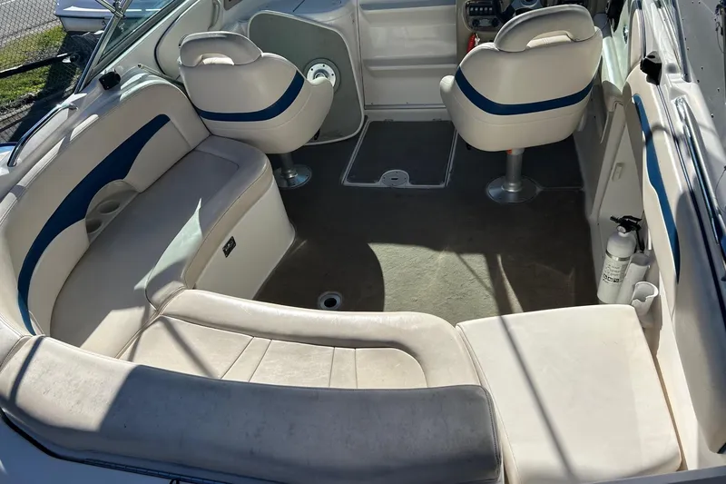 Slide: The Image of 2001 Chaparral 235 SSi boat interior with white and blue seating, steering area, and fire extinguisher. - 8