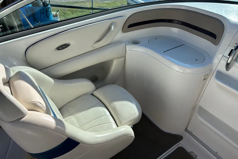 Slide: The Image of Interior of a 2001 Chaparral 235 SSi boat, featuring a white leather seat and storage area. - 9