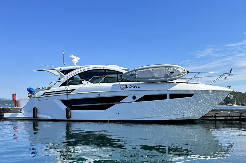 The Image of 2022 Cruisers Yachts 50 Cantius docked on a sunny day, reflecting on calm water. - 0