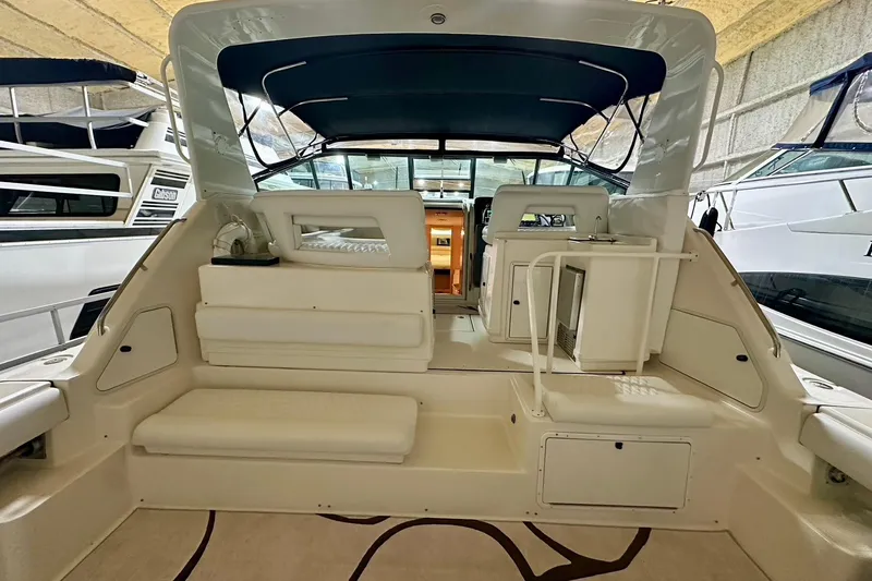 Slide: The Image of 1995 Tiara Yachts 4300 Open interior with seating and helm, docked in marina. - 18