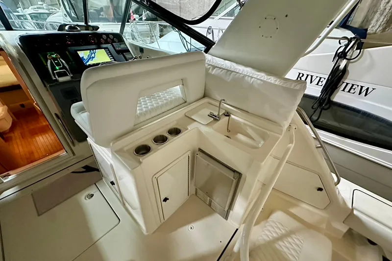 Slide: The Image of 1995 Tiara Yachts 4300 Open cockpit with helm, seating, and built-in sink. - 19