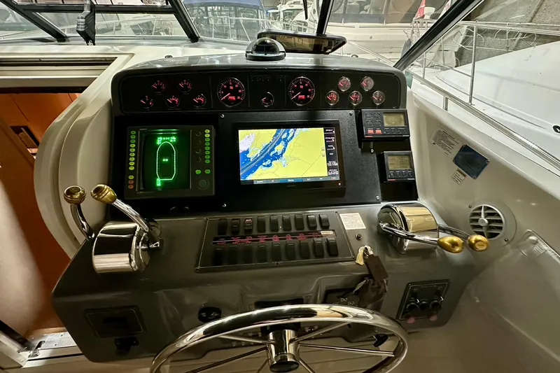 Slide: The Image of 1995 Tiara Yachts 4300 Open helm with navigation screens and controls. - 23