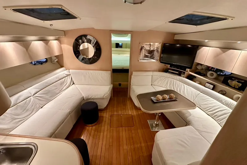Slide: The Image of Luxurious interior of a 1995 Tiara Yachts 4300 Open with white seating and wooden flooring. - 27
