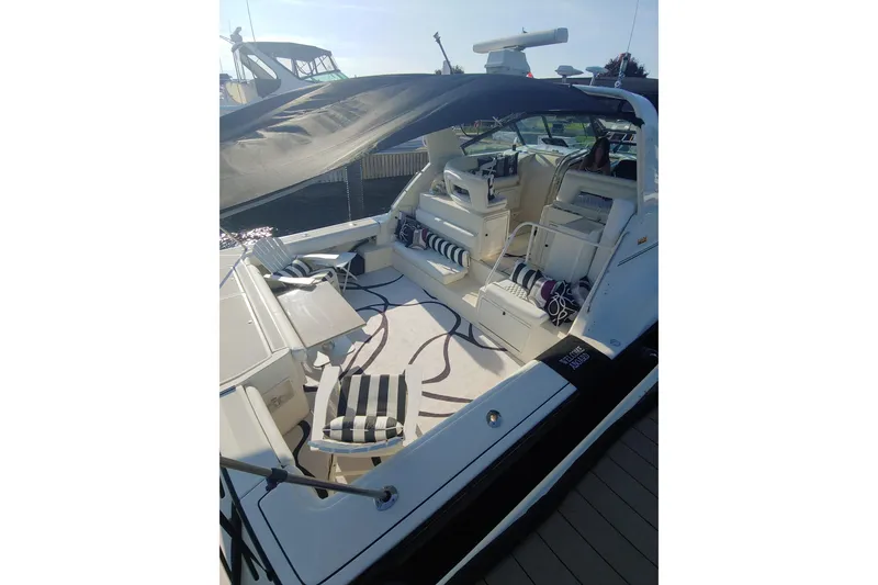 Slide: The Image of 1995 Tiara Yachts 4300 Open with striped seating and spacious deck area. - 4