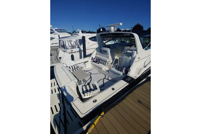 Slide: The Image of 1995 Tiara Yachts 4300 Open docked, showcasing spacious seating and sleek design. - 5