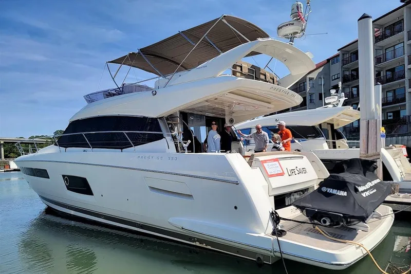 Slide: The Image of 2014 Prestige 550 yacht docked with people on board, featuring sleek design and modern amenities. - 50