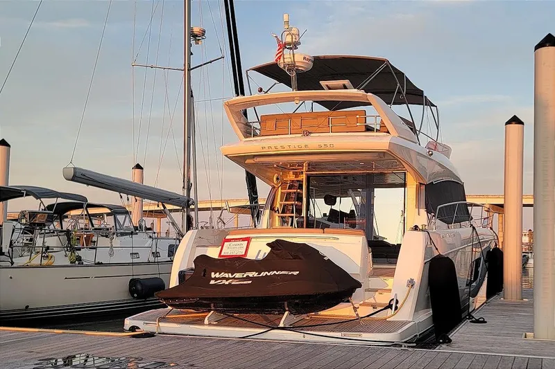 Slide: The Image of 2014 Prestige 550 yacht docked with WaveRunner on deck at sunset. - 52