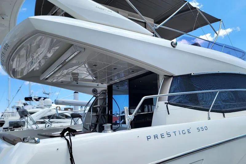 Slide: The Image of Luxury 2014 Prestige 550 yacht docked at marina under clear blue sky. - 54