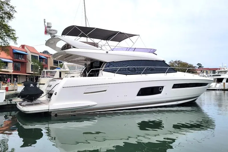 Slide: The Image of Luxury 2014 Prestige 550 yacht docked in marina, featuring sleek design and spacious deck. - 8