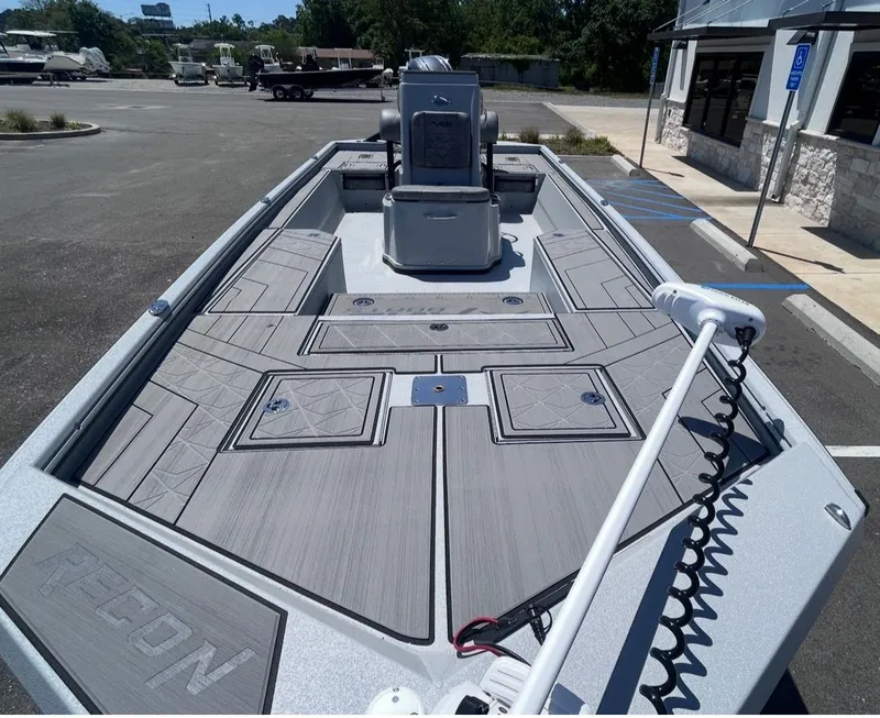 Slide: The Image of Avid 22 Recon 2026 boat with gray deck in a parking lot. - 7