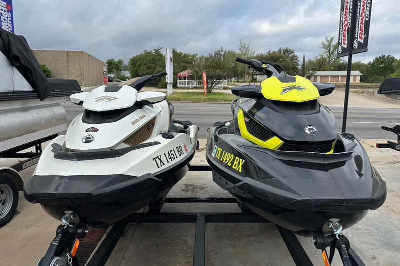The Image of Two Seadoo GTX-IS-LTD 2012 jet skis on trailers, parked outdoors. - 0