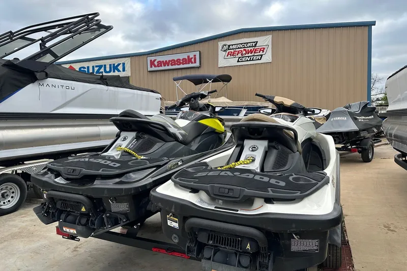 Slide: The Image of 2012 Seadoo GTX-IS-LTD jet skis parked at a dealership with Suzuki and Kawasaki signage. - 3