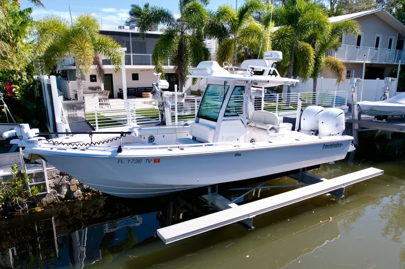 Slide: The Image of 2021 Everglades 273 Center Console boat docked near waterfront home with palm trees. - 1