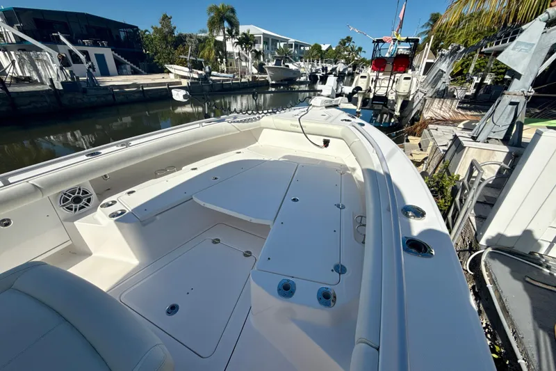 Slide: The Image of 2021 Everglades 273 Center Console boat docked in a marina, showcasing spacious deck and seating. - 10