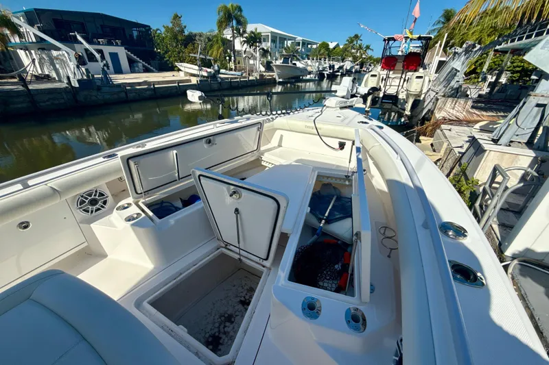 Slide: The Image of 2021 Everglades 273 Center Console boat docked, showcasing open storage compartments and sleek design. - 12