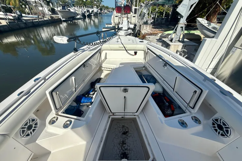 Slide: The Image of 2021 Everglades 273 Center Console boat with open storage compartments, docked in a marina. - 13