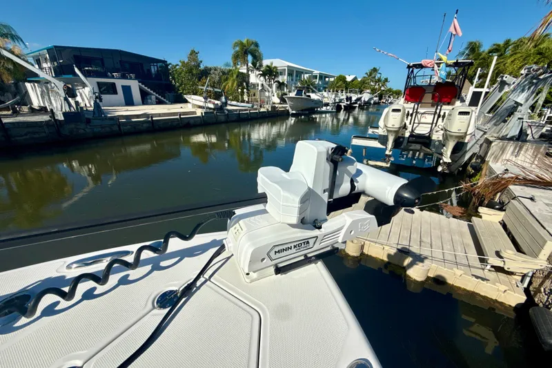 Slide: The Image of Everglades 273 Center Console boat docked by a canal, featuring a Minn Kota motor. - 14