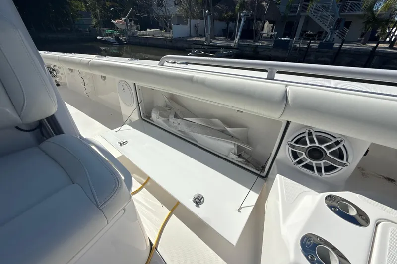Slide: The Image of 2021 Everglades 273 Center Console boat interior with storage compartment and speaker. - 18