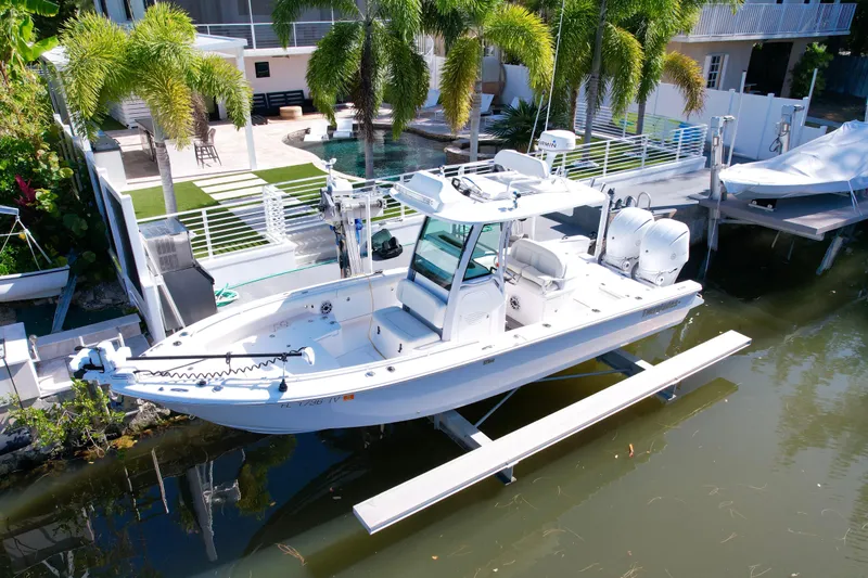 Slide: The Image of 2021 Everglades 273 Center Console boat docked near a luxurious waterfront property. - 2