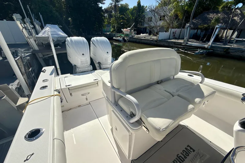Slide: The Image of 2021 Everglades 273 Center Console boat with dual engines docked by a canal. - 20