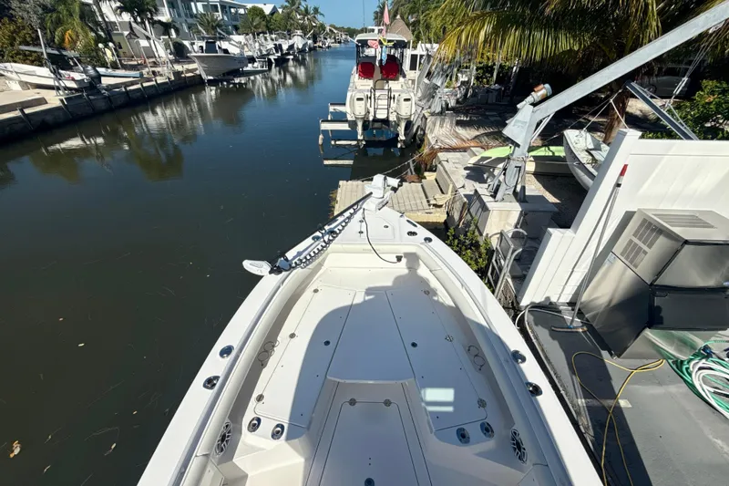 Slide: The Image of 2021 Everglades 273 Center Console boat docked in a scenic canal setting. - 23