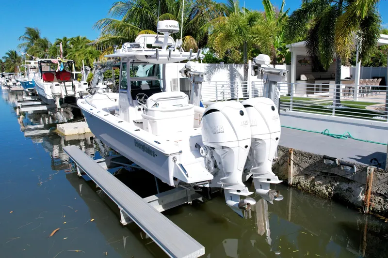 Slide: The Image of 2021 Everglades 273 Center Console boat docked by palm trees. - 3
