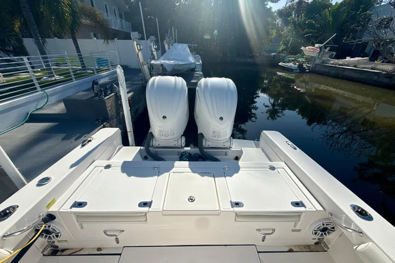 Slide: The Image of 2021 Everglades 273 Center Console boat with dual outboard engines docked by a canal. - 5