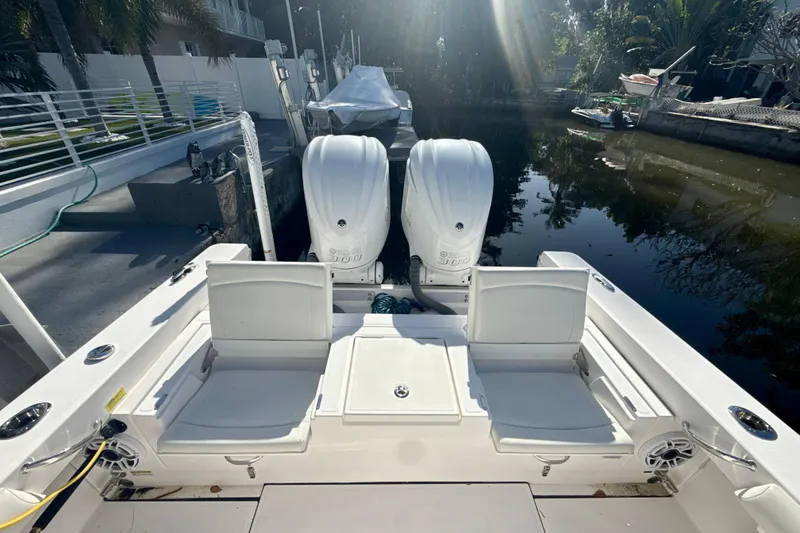 Slide: The Image of 2021 Everglades 273 Center Console boat with dual engines docked by a canal. - 6