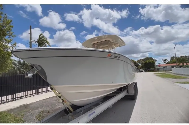 The Image of 2021 Grady-White Canyon 271 FS boat on trailer under a partly cloudy sky. - 0