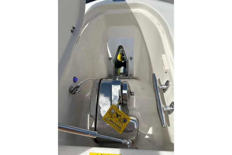 Slide: The Image of 2021 Grady-White Canyon 271 FS boat anchor compartment with warning label and chrome fittings. - 11