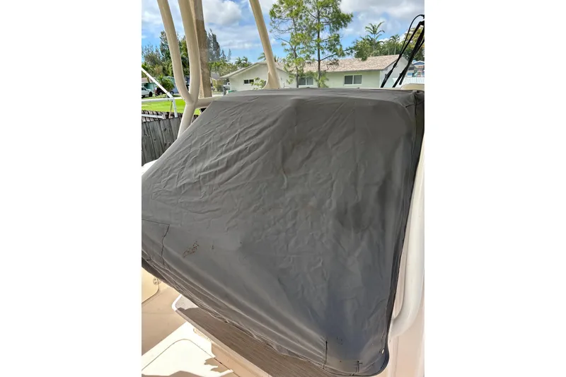 Slide: The Image of 2021 Grady-White Canyon 271 FS boat with protective cover, outdoor setting. - 17