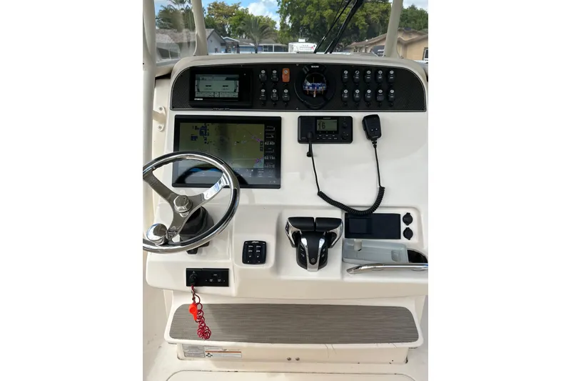 Slide: The Image of 2021 Grady-White Canyon 271 FS boat dashboard with steering wheel and navigation controls. - 8