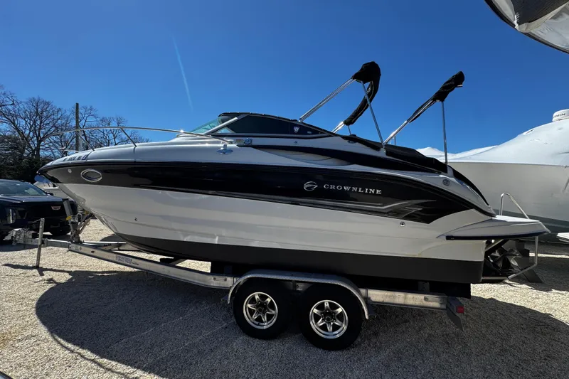 The Image of 2004 Crownline 250 CR boat on trailer under clear blue sky. - 0