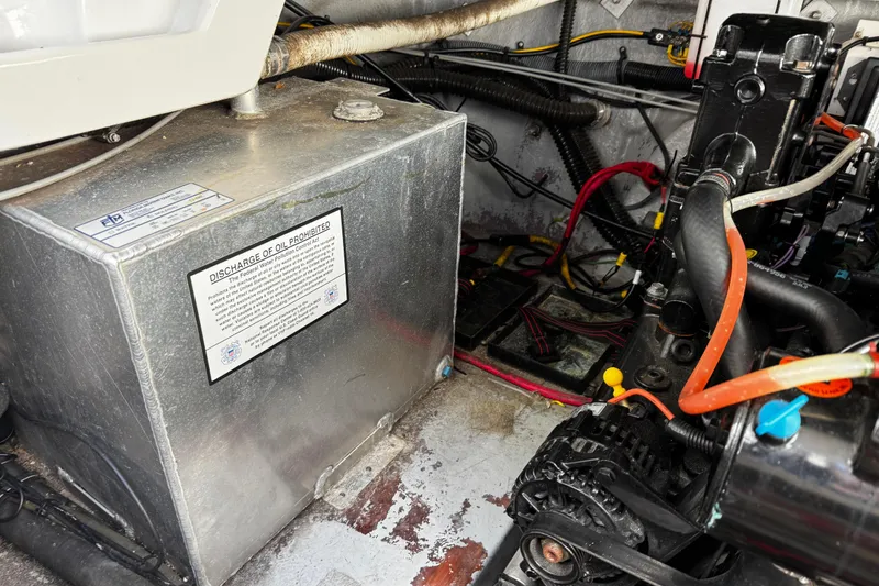 Slide: The Image of Engine compartment of a 2004 Crownline 250 CR boat, showing oil discharge warning. - 108