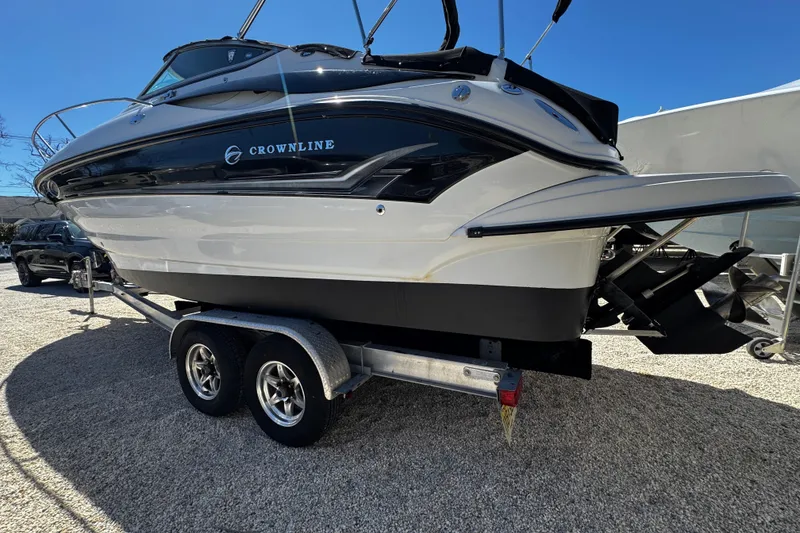 Slide: The Image of 2004 Crownline 250 CR boat with black canopy, parked outdoors. - 13