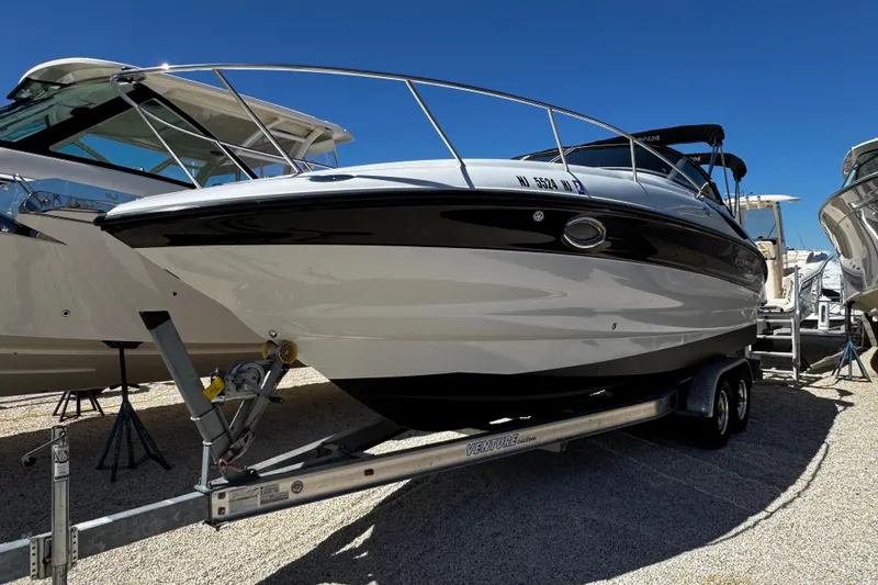 Slide: The Image of 2004 Crownline 250 CR boat on trailer, displayed outdoors under clear blue sky. - 2