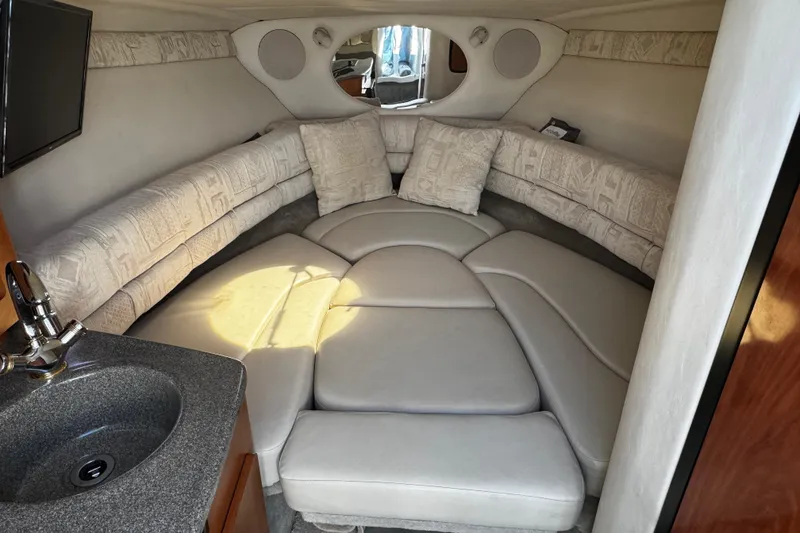Slide: The Image of 2004 Crownline 250 CR cabin interior with wood paneling and compact sleeping area. - 27