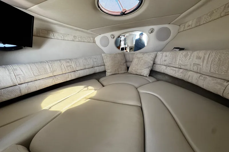 Slide: The Image of Interior cabin of a 2004 Crownline 250 CR boat, featuring cushioned seating. - 29