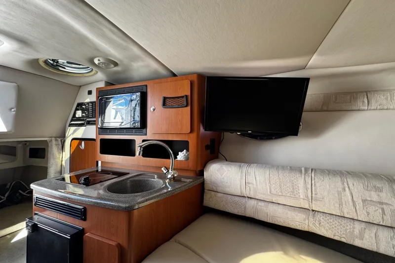 Slide: The Image of 2004 Crownline 250 CR cabin interior with beige upholstery and mirror. - 30