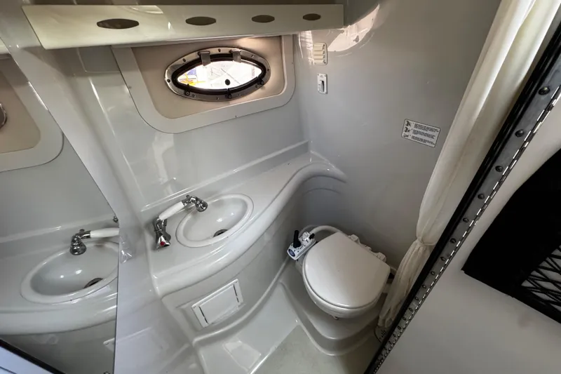 Slide: The Image of Interior of a 2004 Crownline 250 CR boat with kitchenette and cozy seating area. - 32