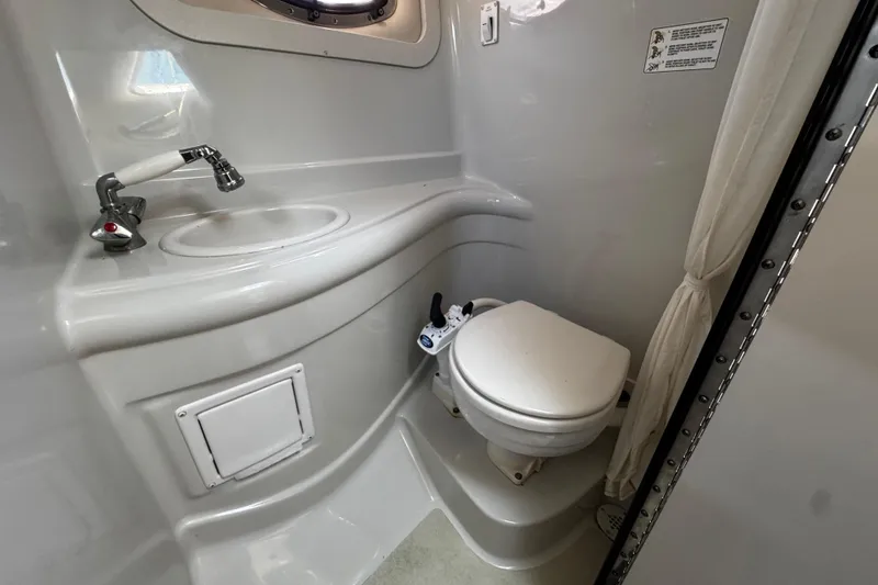 Slide: The Image of 2004 Crownline 250 CR cabin interior with kitchenette, microwave, and seating area. - 33