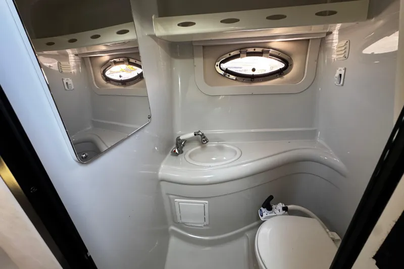 Slide: The Image of 2004 Crownline 250 CR cabin interior with plush seating and compact sink area. - 34