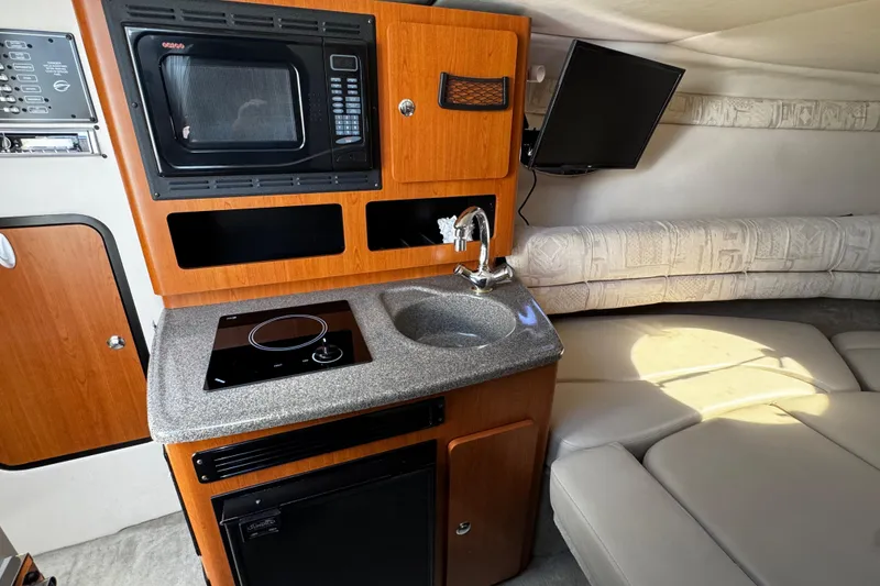 Slide: The Image of 2004 Crownline 250 CR cabin interior with plush seating and porthole windows. - 35