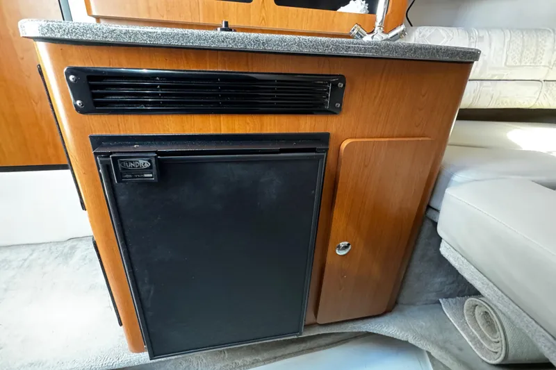 Slide: The Image of Interior of 2004 Crownline 250 CR boat with plush seating and a mounted TV. - 36