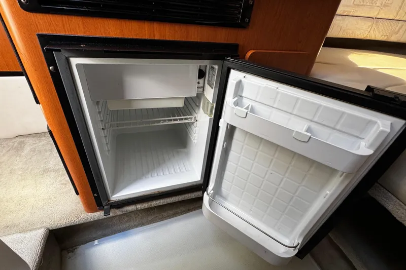 Slide: The Image of 2004 Crownline 250 CR cabin interior with kitchenette, TV, and seating area. - 37