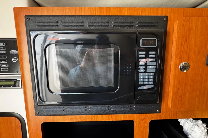 Slide: The Image of 2004 Crownline 250 CR boat bathroom with sink, toilet, and porthole window. - 39