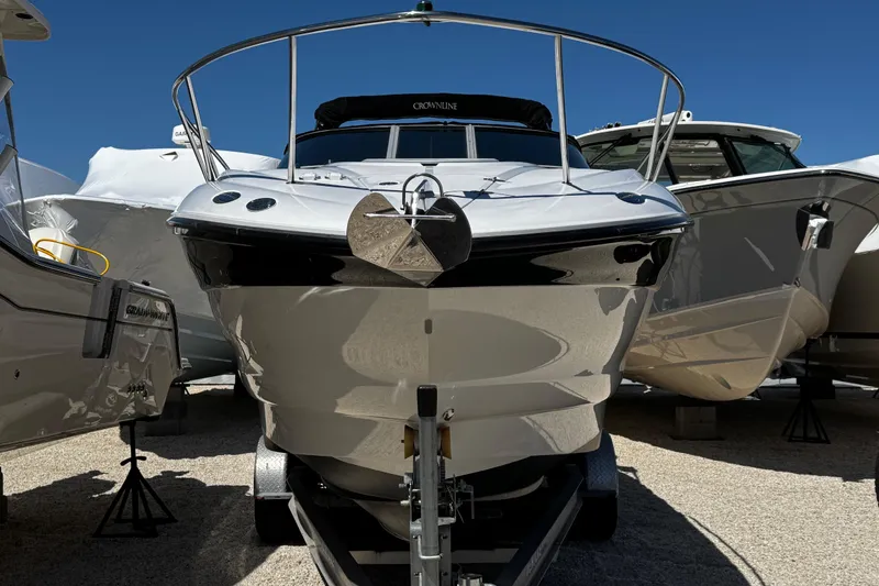 Slide: The Image of 2004 Crownline 250 CR boat on trailer, surrounded by other boats, under clear blue sky. - 4