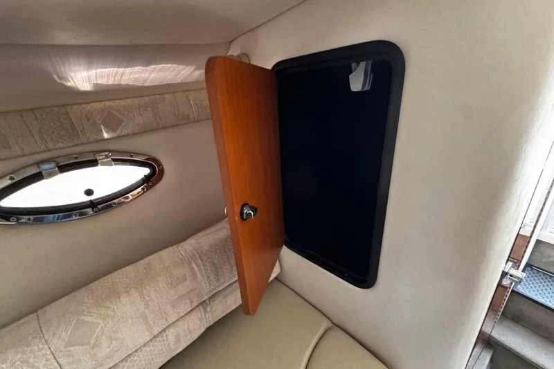Slide: The Image of 2004 Crownline 250 CR boat interior with kitchenette, sink, and microwave. - 47